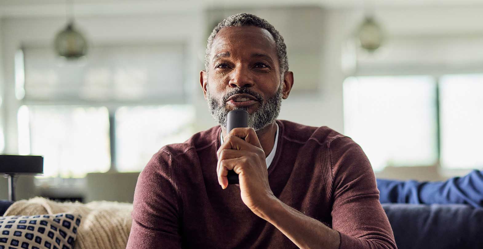 a man talking to his TV remote