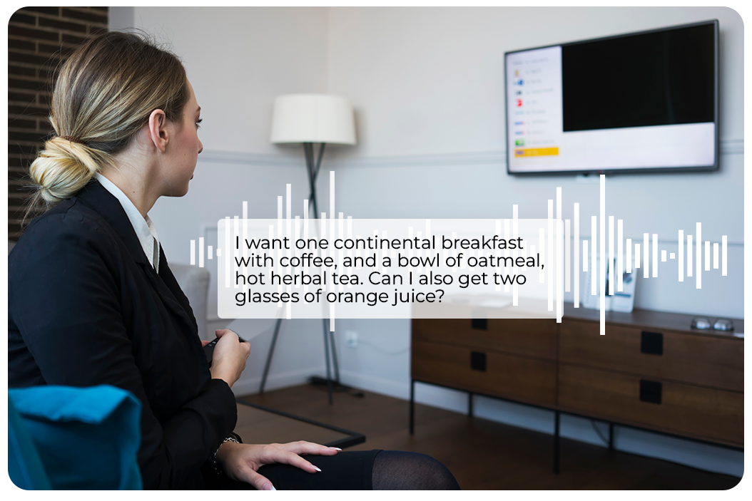 a woman talking to a voice-enabled tv in a hotel room